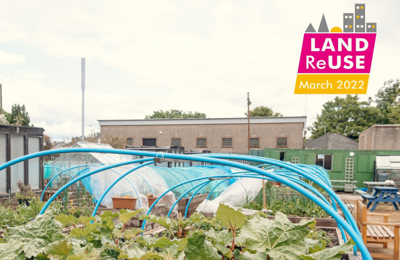 Land Reuse Month logo - raised beds with food growing in front of urban buildings in Shettleston - credit Ryan Johnston