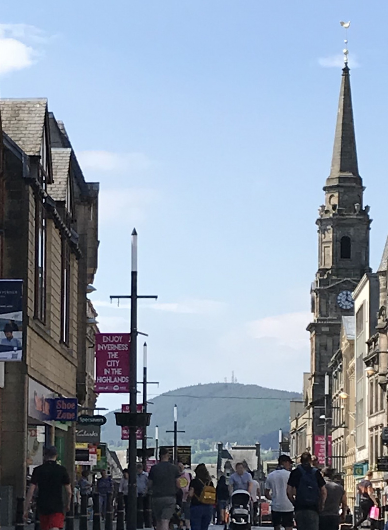 A view of Inverness High Street with church and shops.