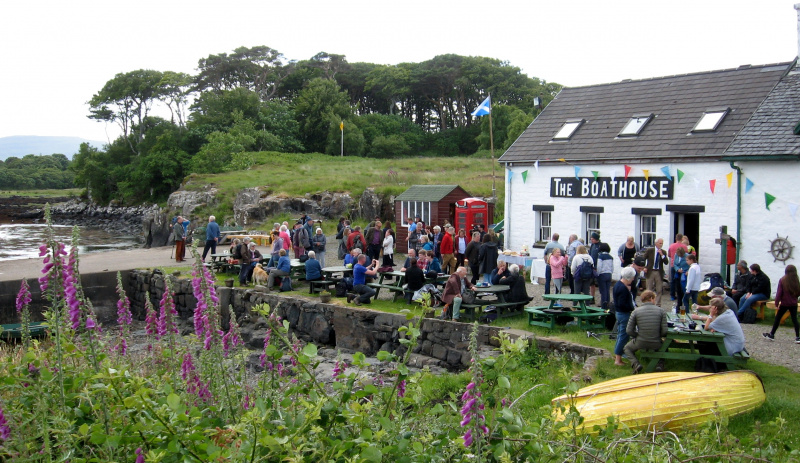 People sitting and standing outside the Boathouse in Ulva, celebrating community buyout